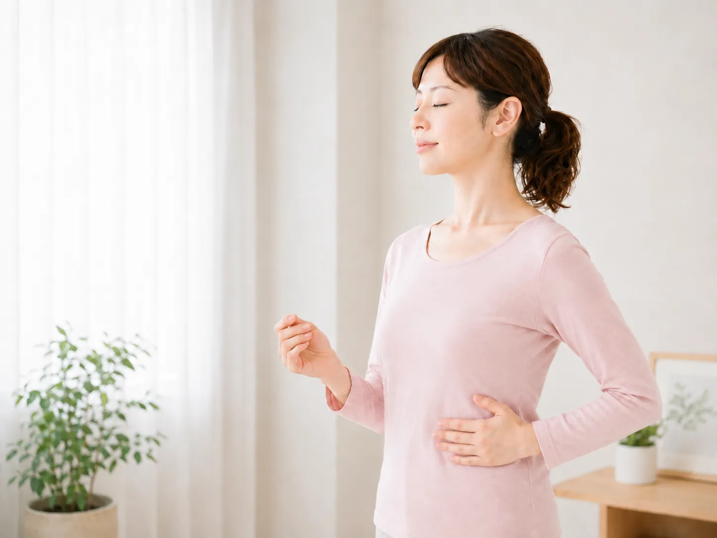片手を下部肋骨に添え、手の動きを静かにしながら話し声を整えるイメージ